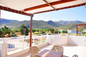 a balcony with chairs and a view of mountains at Lagos Studios & Apartments in Palekastron