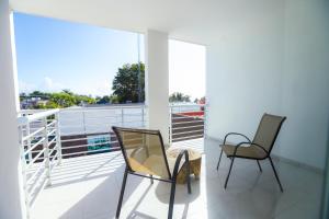 2 sillas sentadas en un balcón con vistas en TRYP by Wyndham Chetumal en Chetumal