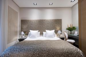 um quarto com uma cama grande e almofadas brancas em Hospes Palacio del Bailio, a Member of Design Hotels em Córdoba