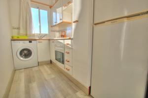 a kitchen with a washing machine and a washer at Parque Playa, in the heart of La Cala de Mijas. in La Cala de Mijas
