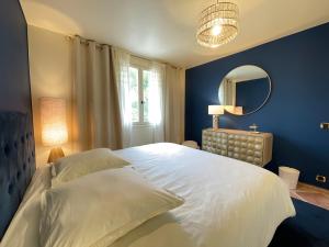 um quarto com uma grande cama branca e um espelho em O' Cocooning - Appart dans Bastide proche Aix em Rousset