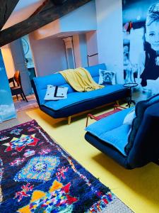 a living room with a blue couch and a rug at L’inattendu in Uzès