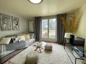 uma sala de estar com um sofá e uma televisão em O' Cocooning - Appart dans Bastide proche Aix em Rousset