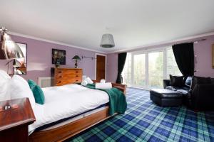 um quarto com uma cama grande e uma cadeira em Strathendrick House Magnificent property with Garden em Drymen