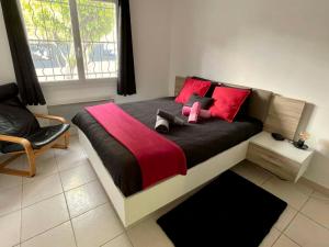 um quarto com uma cama com um bicho de peluche cor-de-rosa em Key Largo villa 2p avec pkg clim grande terrasse avec jacuzzi proche port et plage em Bandol