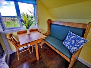 a room with a bench and a table and a window at Bluebell in Newton Stewart