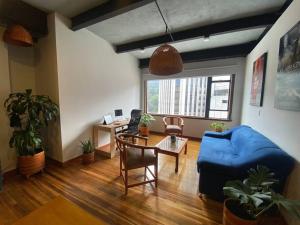 sala de estar con sofá azul y mesa en Modern loft with beautiful Mountain View in Bogotá, en Bogotá