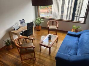 - un salon avec un canapé bleu et des chaises dans l'établissement Modern loft with beautiful Mountain View in Bogotá, à Bogotá