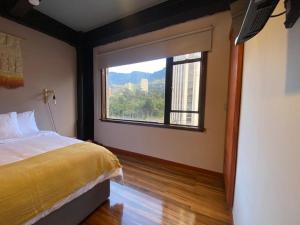 1 dormitorio con cama y ventana grande en Modern loft with beautiful Mountain View in Bogotá, en Bogotá