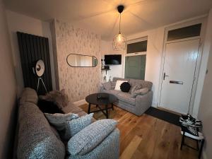uma sala de estar com um sofá e uma mesa em Centrally located in city of Lincoln Idas Place - two bedrooms each with a kingsize bed em Lincolnshire