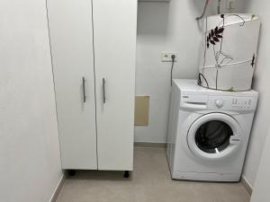 eine Waschküche mit einer Waschmaschine und Schränken in der Unterkunft Apartamento Cala Ratjada. Recién reformado in Cala Ratjada