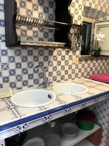 2 lavabos en un baño con azulejos azules y blancos en Villa Ederle en La Maddalena