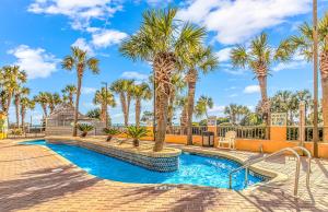 a swimming pool with palm trees in a resort at Caravelle 1512 in Myrtle Beach