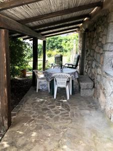 un patio con mesa y sillas bajo una pared de piedra en Villa Ederle en La Maddalena