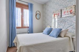 a bedroom with a bed with blue walls and a window at La Lancha in El Torno