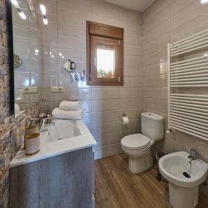 a bathroom with a white toilet and a sink at La Lancha in El Torno