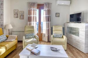 a living room with a couch and chairs and a tv at La Lancha in El Torno