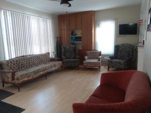 a living room with a couch and two chairs at Auberge Jeunesse à Loulou in Lévis