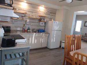 a kitchen with a white refrigerator and a table at Auberge Jeunesse à Loulou in Lévis