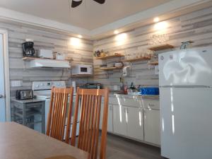 cocina con electrodomésticos blancos y nevera blanca en Auberge Jeunesse à Loulou, en Lévis