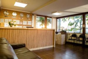 a lobby with a bar with clocks on the wall at Pousada Sossego da Pampulha in Belo Horizonte