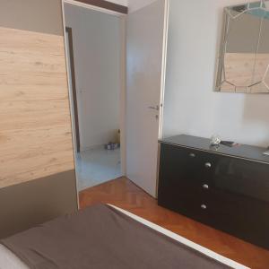 ブロダリツァにあるApartman Ivaのベッドルーム(黒いドレッサー、鏡付)