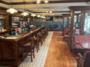 un bar en un restaurante con mesas y sillas de madera en Hotel Newport, en Newport