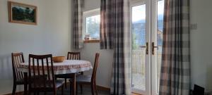 a table and chairs in a room with a window at The Shelter Stone Cottage in Aviemore