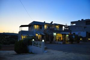 a large house with the lights on at dusk at Lagos Studios & Apartments in Palekastron