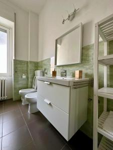 a bathroom with a sink and a toilet and a mirror at Casa Lamar in Salerno