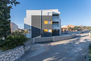a building with a stone wall next to a street at Nautilus Apartment II Whirlpool in Novalja