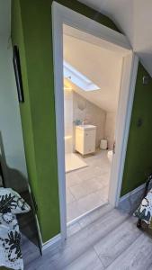 an open door to a bathroom with green walls at Manchester, Rusholme, UK with free parking in Manchester