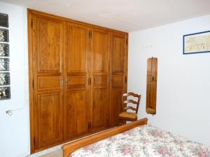 1 dormitorio con armario de madera y silla en Propriete d'une chambre avec jardin clos et wifi a La Mothe Saint Heray, en La Mothe-Saint-Héray