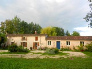 una vieja casa de piedra en un campo de hierba en Propriete d'une chambre avec jardin clos et wifi a La Mothe Saint Heray, en La Mothe-Saint-Héray
