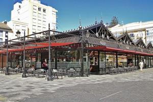 a building with tables and chairs on a street at Piso Vintage Centro Gandía in Gandía