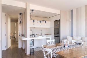 a kitchen and a living room with a table and chairs at San Vito Luxury Accomodation in Polignano a Mare