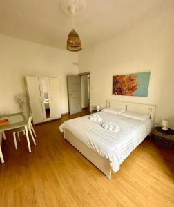 a bedroom with a large white bed and a table at Casa Lamar in Salerno