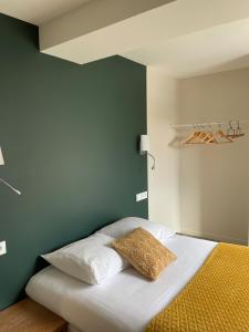 ein Bett mit zwei Kissen darauf in einem Schlafzimmer in der Unterkunft Restaurant Hotel Logis Chez Sophie in Briouze