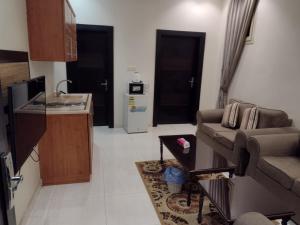 uma sala de estar com um sofá e uma cozinha em شقق النرجس فيلا للشقق المخدومة em Riyadh