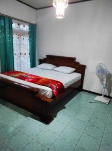 a bedroom with a bed with a fan at HOMESTAY KARTINI SYARIAH in Bukittinggi