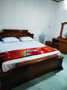 a bedroom with a bed with a blanket on it at HOMESTAY KARTINI SYARIAH in Bukittinggi