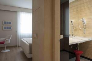 a bathroom with a sink and a bed in a room at San Gil Plaza Hotel in Zamora +23 photos