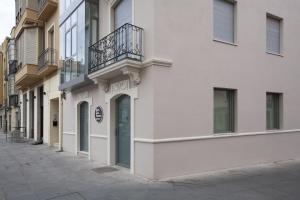 a white building with a balcony on a street at San Gil Plaza Hotel in Zamora