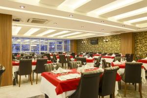 a restaurant with red and white tables and chairs at Royal Hotel Inegol in Inegol