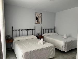 コルドバにあるオスタル アルマンソルのベッドルーム1室(ベッド2台付)が備わります。壁に絵が描かれています。