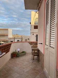 un balcone con tavolo e sedie su un edificio di Paste&cannola a Lampedusa