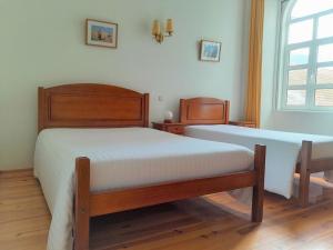 a bedroom with two twin beds and a window at Hotel Alianca in Figueira da Foz