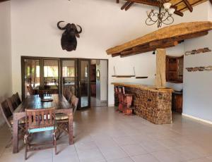 a dining room with a table and chairs and a fireplace at Makhato Bush Lodge 48 in Bela-Bela