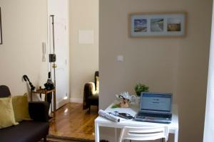 a living room with a laptop on a white table at Romantic & Renewed 1 bedroom Apartment in Campolide - 67 1E in Lisbon