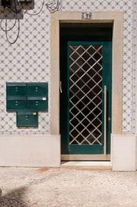 a green door with a metal gate on a building at Romantic & Renewed 1 bedroom Apartment in Campolide - 67 1E in Lisbon